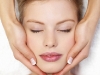Closeup of human hands massaging a young pretty woman's face